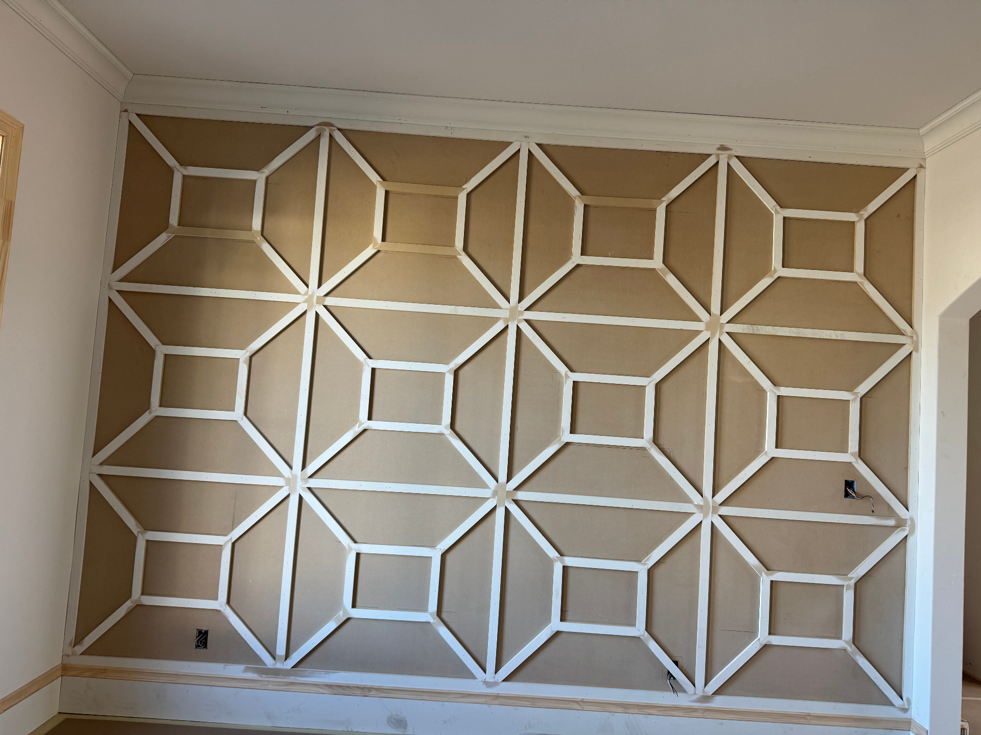 In-progress geometric accent wall millwork installation